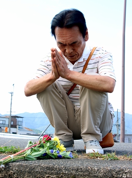 献花後、手を合わせる丹波市の男性