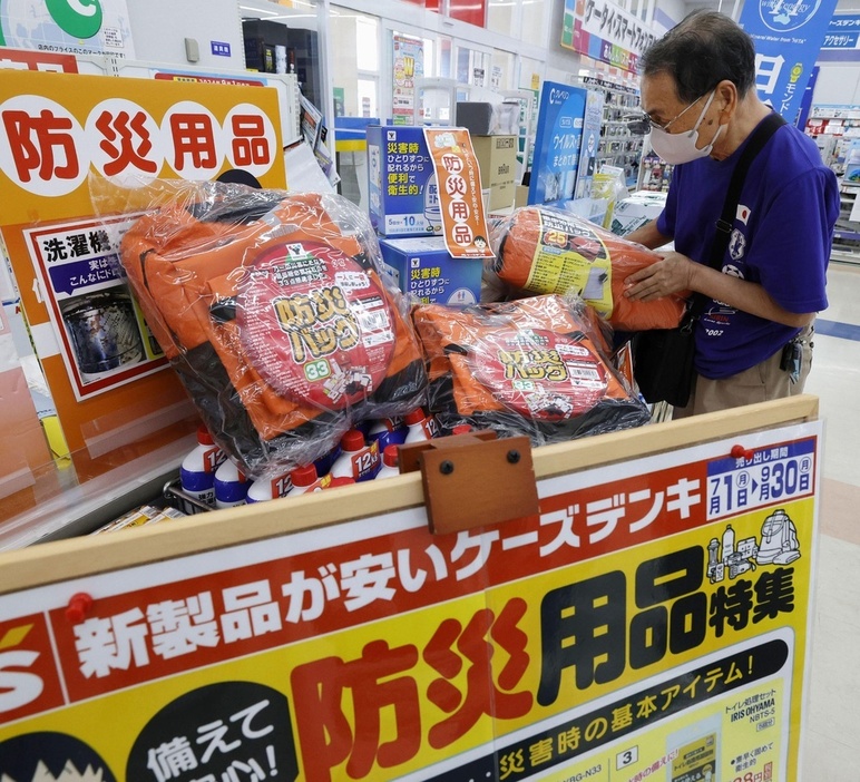 家電量販店に設置された防災用品のコーナーを見る男性＝9日、鹿児島県志布志市