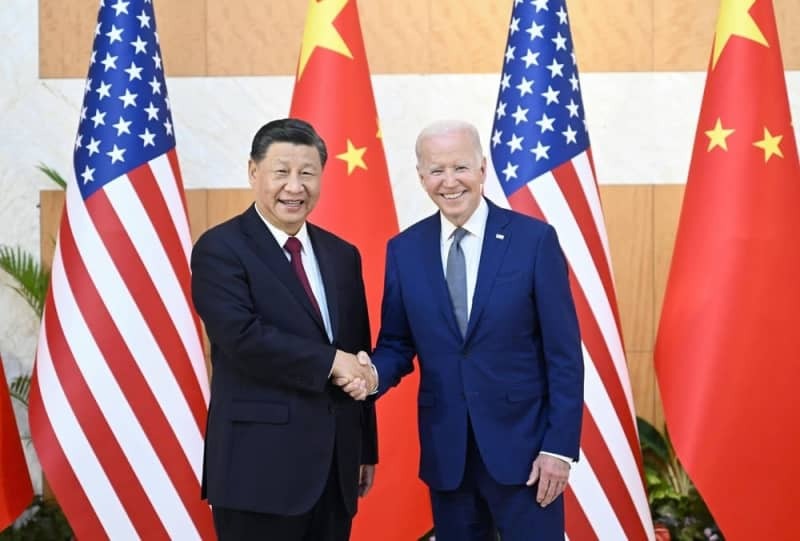 中国の習近平国家主席（左）と握手するバイデン米大統領＝２０２２年１１月、インドネシア・バリ島（新華社＝共同）