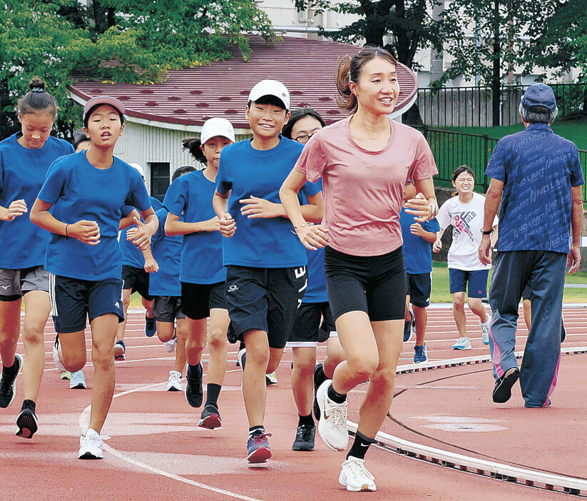 児童とランニングで汗を流す五島選手＝１７日午前９時３５分、金沢市営陸上競技場