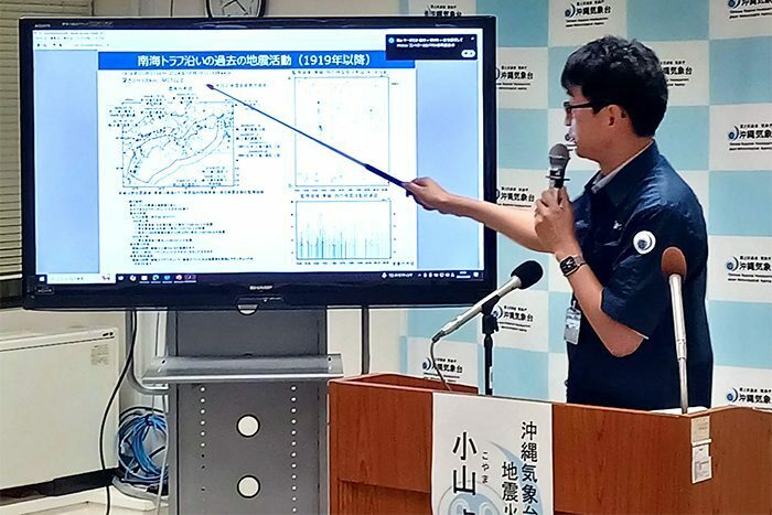 南海トラフ地震の仕組みや沖縄への影響について説明する沖縄気象台の職員＝8日午後8時、那覇市の沖縄気象台