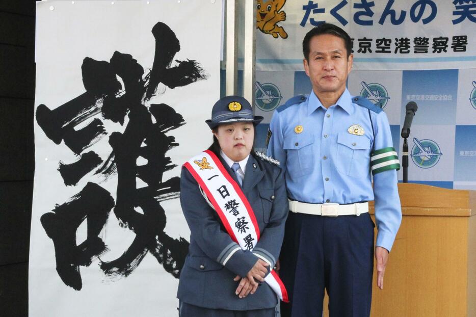 一日署長に任命された金沢翔子さん。右は警視庁東京空港署の川元一郎署長＝21日午前、東京都大田区