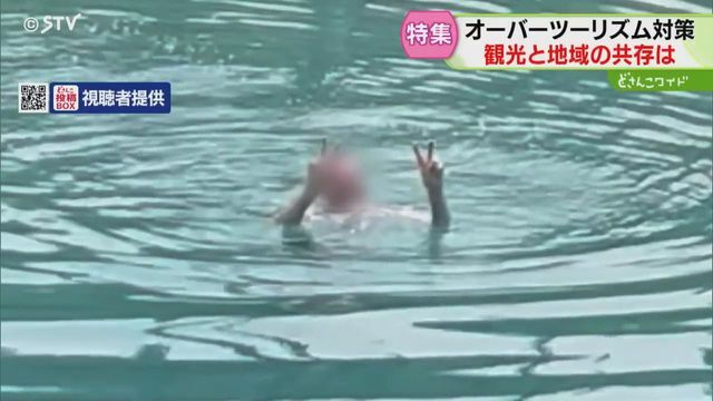 外国人とみられる男性が池で泳ぐ