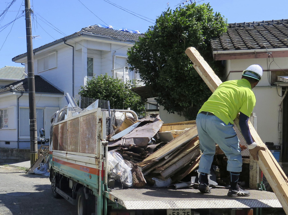 散乱したがれきを撤去する作業員＝31日午前10時34分、宮崎市