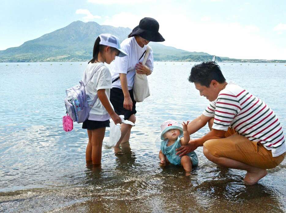 水遊びを楽しむ家族連れ＝７月３１日、鹿児島市の磯海水浴場