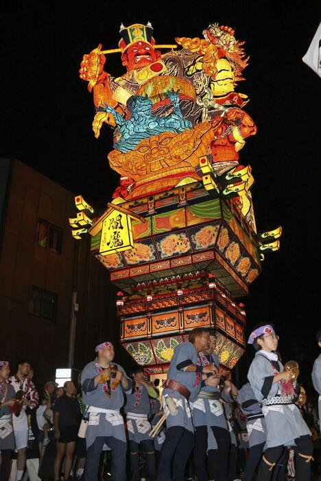 市街地を練り歩く、閻魔大王が裁きを下す姿を表現した山車＝4日夜、青森県五所川原市