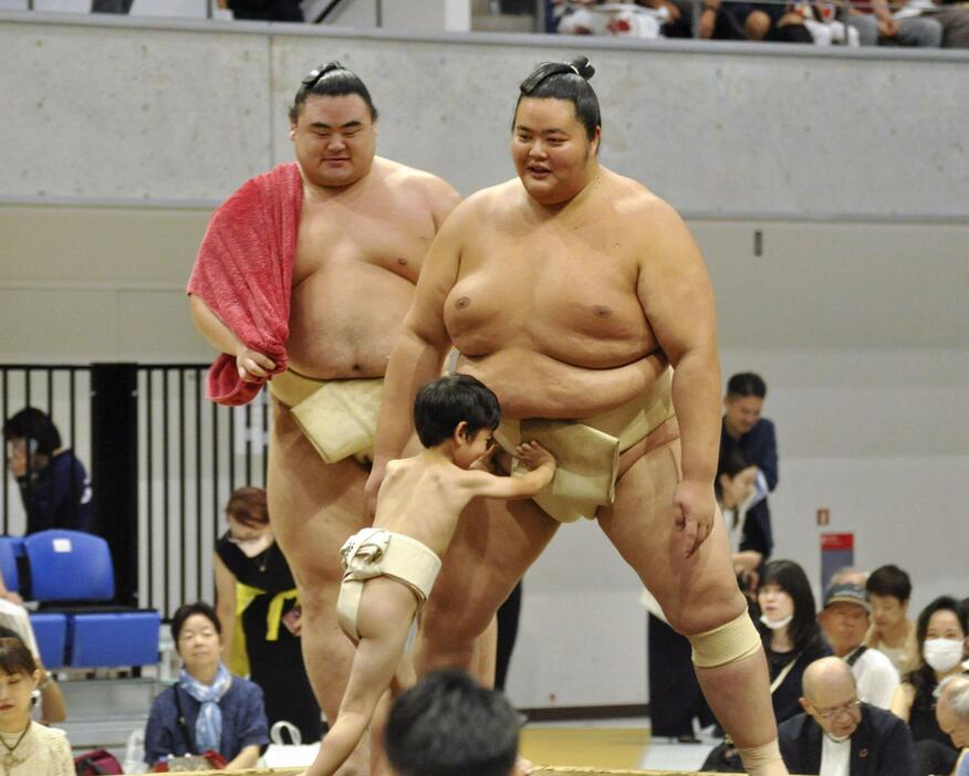 大相撲の夏巡業で子どもに胸を出し、会場を盛り上げる琴桜（右）＝8日、東京都立川市