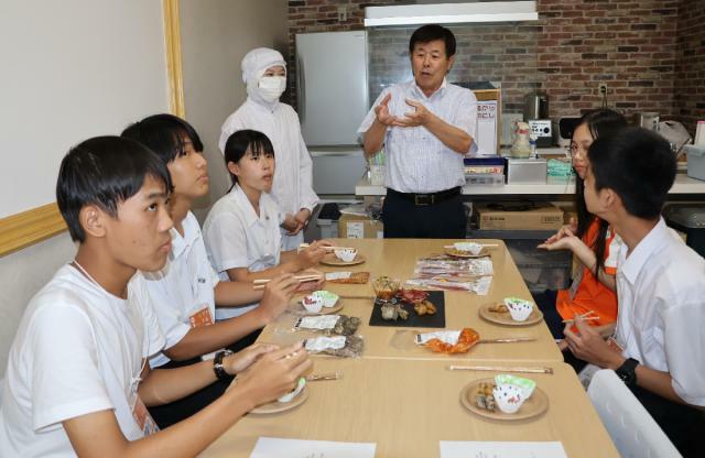 栗山ノーサンの豚足や酢モツなどを試食する高校生ら