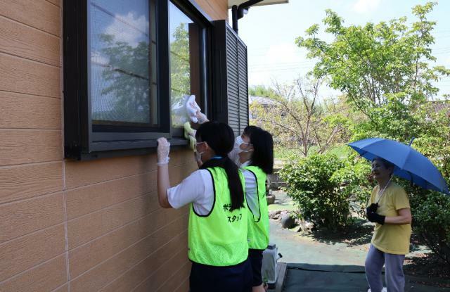 困りごとお助け隊の活動で高齢者宅の窓を拭く加久藤中の生徒