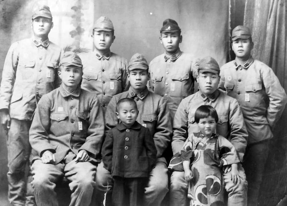 １９４５年春、積兵団の兵士と記念撮影する４歳の澤俊文さん（前列中央）と幼なじみの桑原和子さん（同右）＝澤さん提供