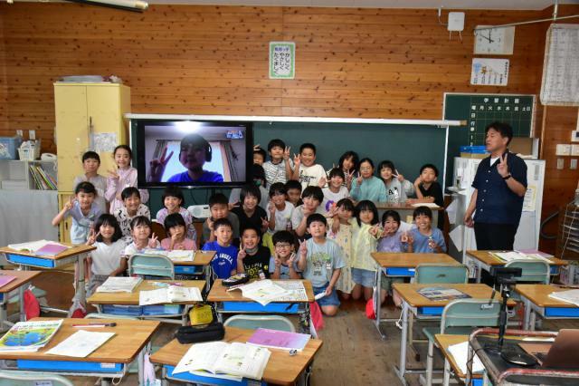 リモートの画面越しに授業に参加する前田千裕さんと、担任の徳丸幸平教諭（右）、クラスメートたち