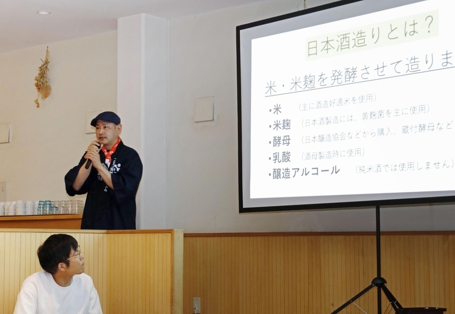 日本酒造りについてプレゼンする「ニセコ発酵ツーリズム推進協議会」会長の水口渉さん（左上）＝7月6日、北海道ニセコ町