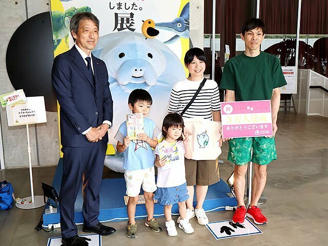 ３万人目の来場者となった石崎奏汰さん（左から２人目）と家族ら