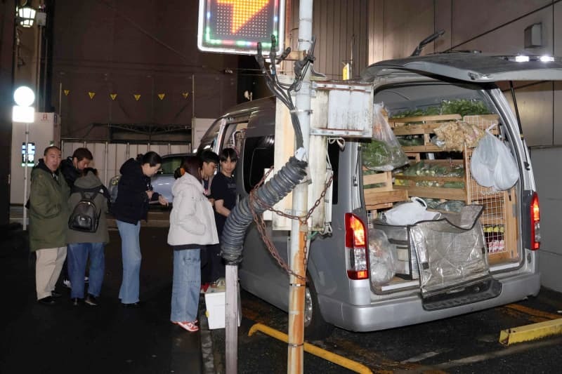 東京都内でタイ野菜の移動販売車に並ぶ外国人ら＝３月２７日午前０時半ごろ、東京都文京区