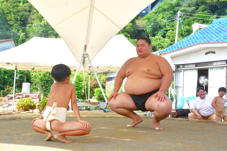 土俵で稽古をつけてもらう少年力士