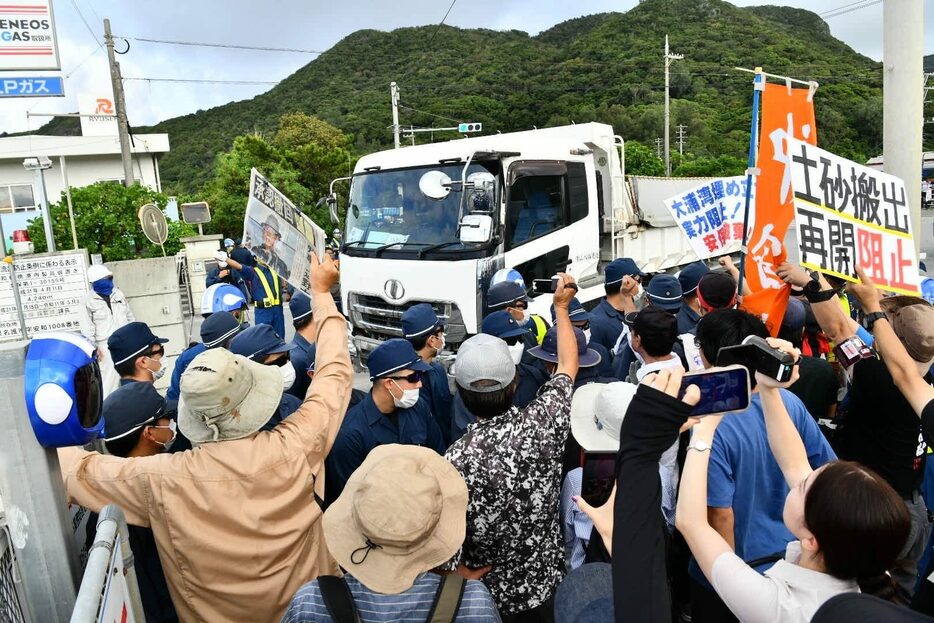 市民らの抗議の中、安和桟橋に入っていく土砂を積んだダンプカー＝22日午前7時51分、名護市安和（喜瀬守昭撮影）