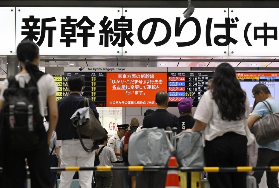 JR新大阪駅で東海道新幹線のダイヤの掲示板を見る利用客ら＝7月22日