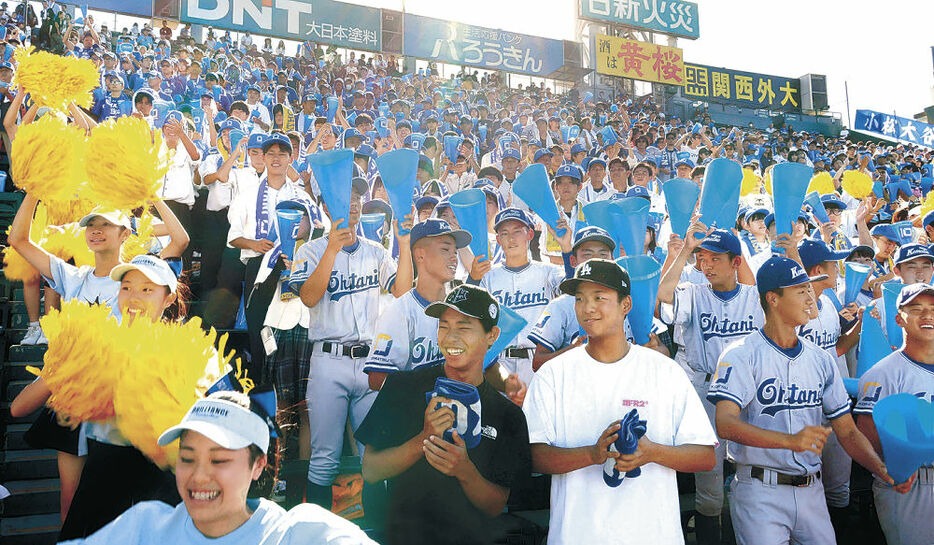 小松大谷の野球部員と一緒に声援を送る能登高の竹下さん（前列右から３人目）と新出さん（同４人目）＝甲子園球場