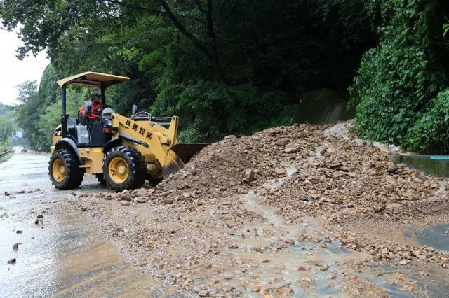 道路脇の山から土砂や濁った水が流れ込んだ影響で、通行止めとなった宮崎市高岡町浦之名の国道２６８号＝２８日午後２時２５分