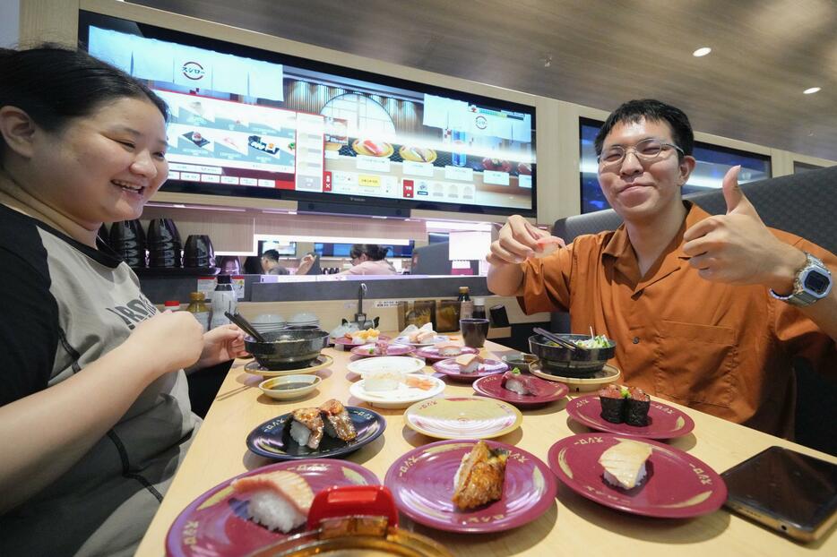 開業した「スシロー」の北京市での第1号店ですしを食べる人たち＝21日（共同）