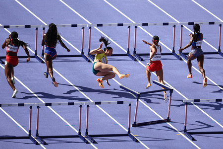 パリ五輪、陸上女子100メートルハードル予選。転倒するオーストラリアのミシェル・ジェネキ（中央、2024年8月7日撮影）。