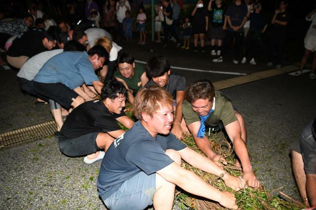 負けじと全力で大綱を引く参加者たち＝18日　宮国公民館前