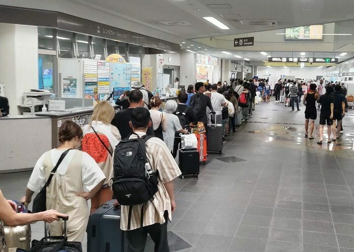 宮古空港で搭乗受け付けを待ち、長蛇の列を作る利用者ら＝19日午前11時20分ごろ、宮古島市平良