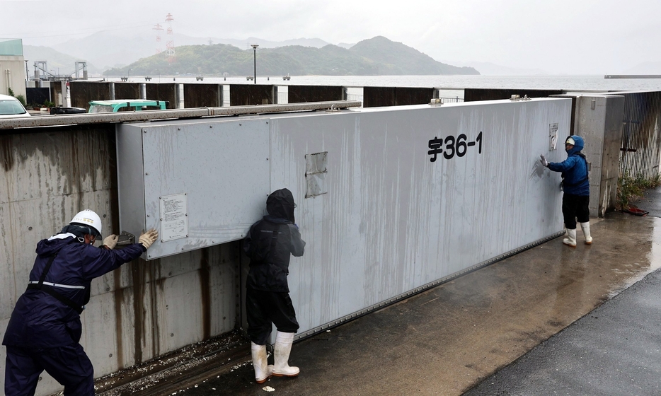 台風10号の接近に備え、広島港の防潮扉を閉じる作業員＝29日午後3時11分、広島市南区