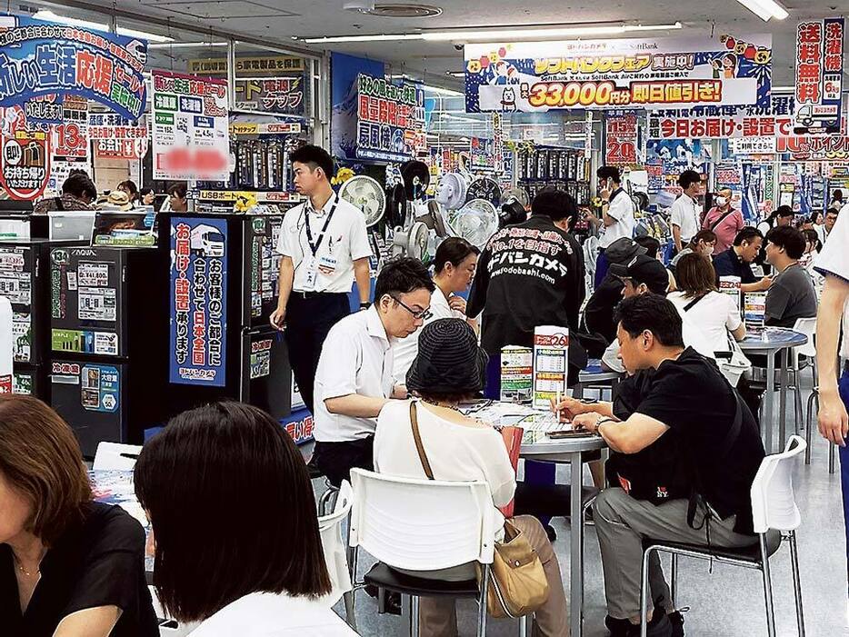 東京都内の家電量販店でエアコンを購入する来店客