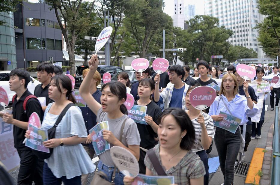 東京都庁付近をデモ行進する人たち＝27日午後、東京都新宿区