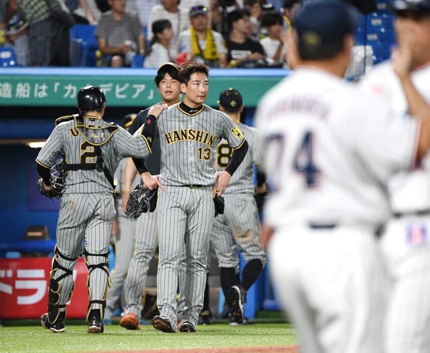 　９回、村上にサヨナラ打を浴び、梅野（左）にねぎらわれる岩崎。後方は才木（撮影・佐々木彰尚）