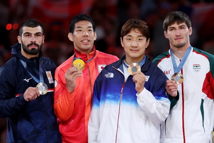 パリ五輪の表彰式では金メダリストにもかかわらず、永瀬（左から2人目）は控え目な位置に立っていた。(C) Getty Images