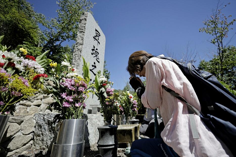 「御巣鷹の尾根」にある「昇魂之碑」に手を合わせる遺族の女性＝12日午前、群馬県上野村