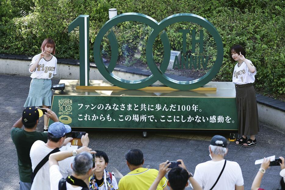 甲子園球場の100周年記念モニュメント前で記念撮影する人たち＝1日、兵庫県西宮市