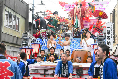 太鼓の音を響かせながら商店街を進む風流山車