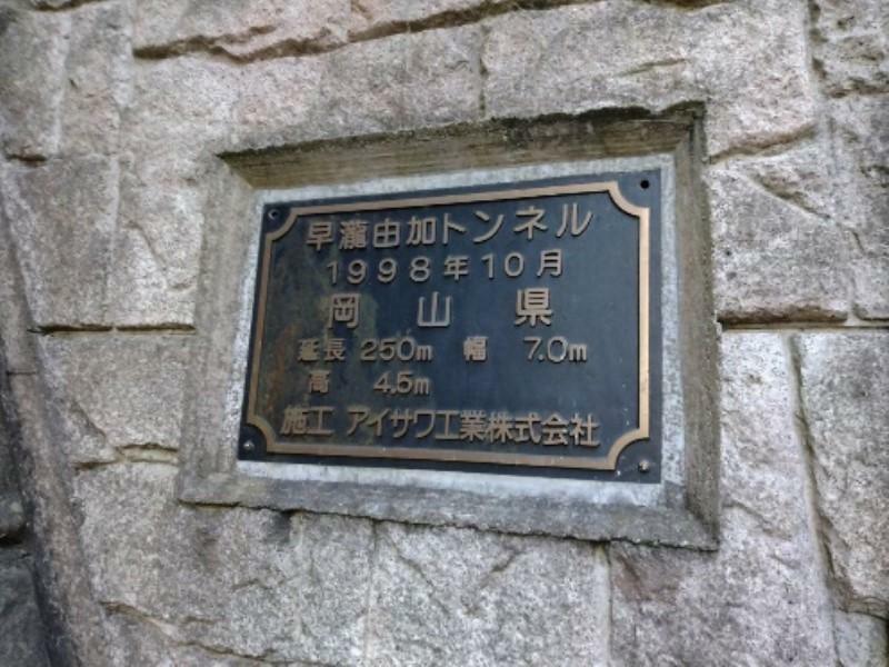 早瀧由加トンネルの標示板。2枚のうち1枚が盗まれ、残った1枚も一部のボルトが外されていた（岡山県提供）