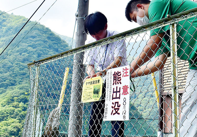 クマ襲撃現場付近に注意喚起の看板を設置する、町、県職員＝13日午前10時半ごろ、小鹿野町両神小森