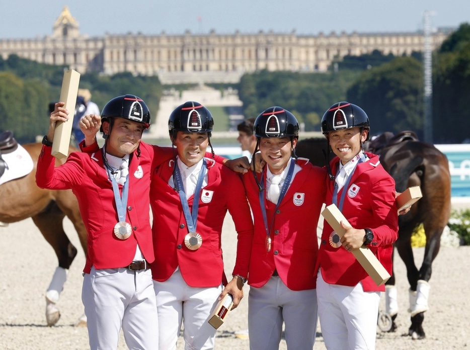 パリ五輪馬術の総合馬術団体で銅メダルを獲得し、写真に納まる（左から）北島隆三、大岩義明、田中利幸、戸本一真＝7月、パリ郊外（共同）