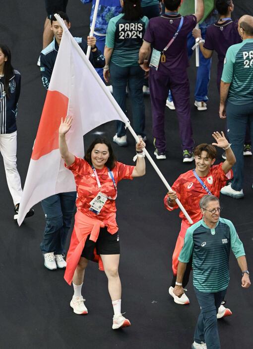 パリ五輪の閉会式で、日の丸を手に入場する旗手の北口榛花（左）と半井重幸＝11日、パリ郊外（共同）