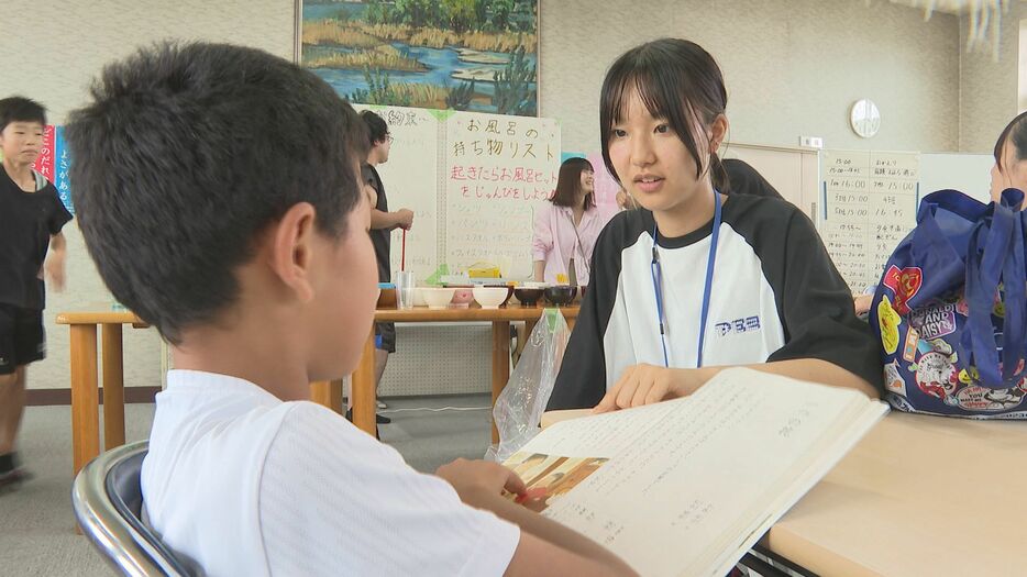 児童の宿題を見る高校生