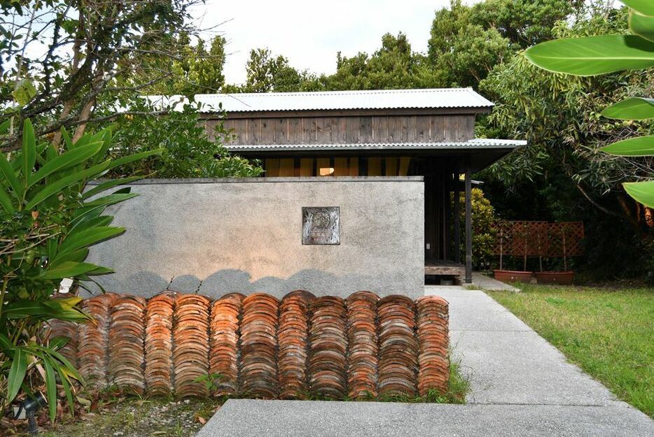 一棟貸しされているモダンな沖縄建築の平屋。入り口に飾られている赤瓦は、かつての家主から「何かに役立ててほしい」と譲られたもの