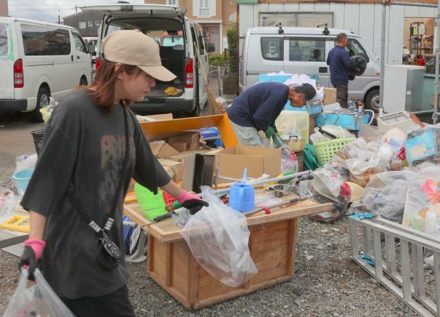 台風１０号に伴う突風の被害を受け、社屋から使えなくなった家具などを運び出す従業員ら＝３０日午前１０時５分、宮崎市赤江