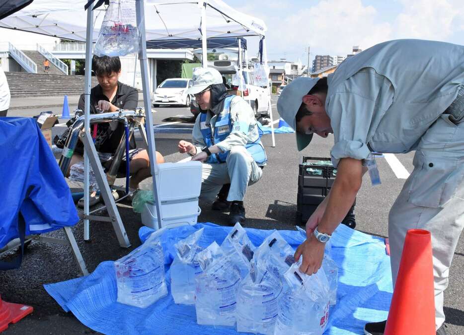 給水車から水を受け取る霧島市民＝１０日、市役所お祭り広場駐車場