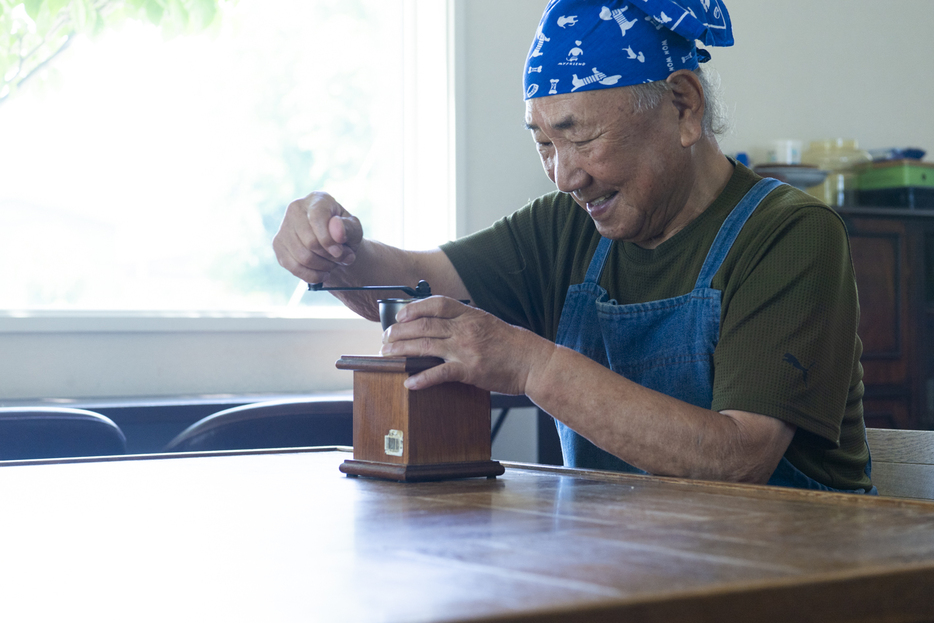 コーヒーを挽くまさるさん。30代の頃からコーヒーを淹れるのが好き。豆をミルでひいて淹れます。お客さんが来たときに喜んでもらえるとうれしい！