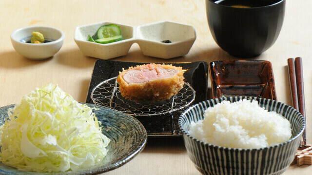 コース定食にはキャベツ、ご飯、みそ汁、小鉢、〆カレーがセットされています