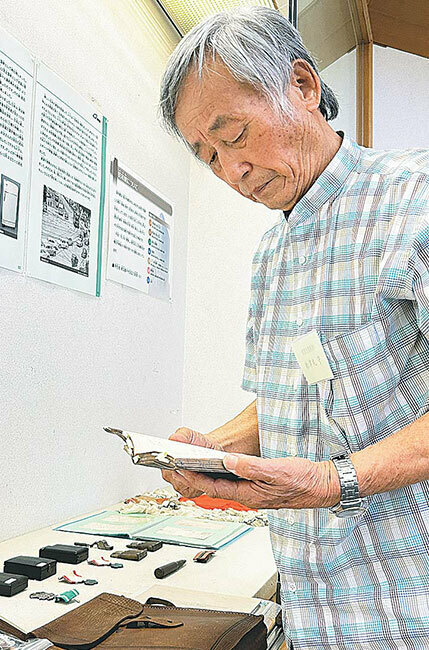 遺品を展示する守さん。100点以上の遺品は全て大切に保管する（佐賀市で）