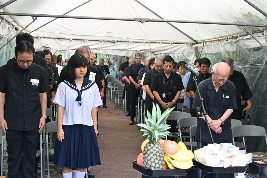 戦争の犠牲となった県立農林学校の生徒や教師らに黙とうする参列者＝15日、嘉手納町の農林健児之塔