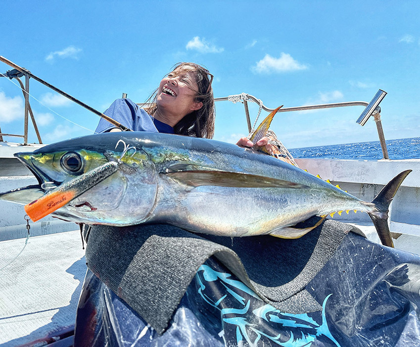 釣ったマグロを膝の上に乗せて記念撮影。ルアーにはしっかりマグロの歯形が。