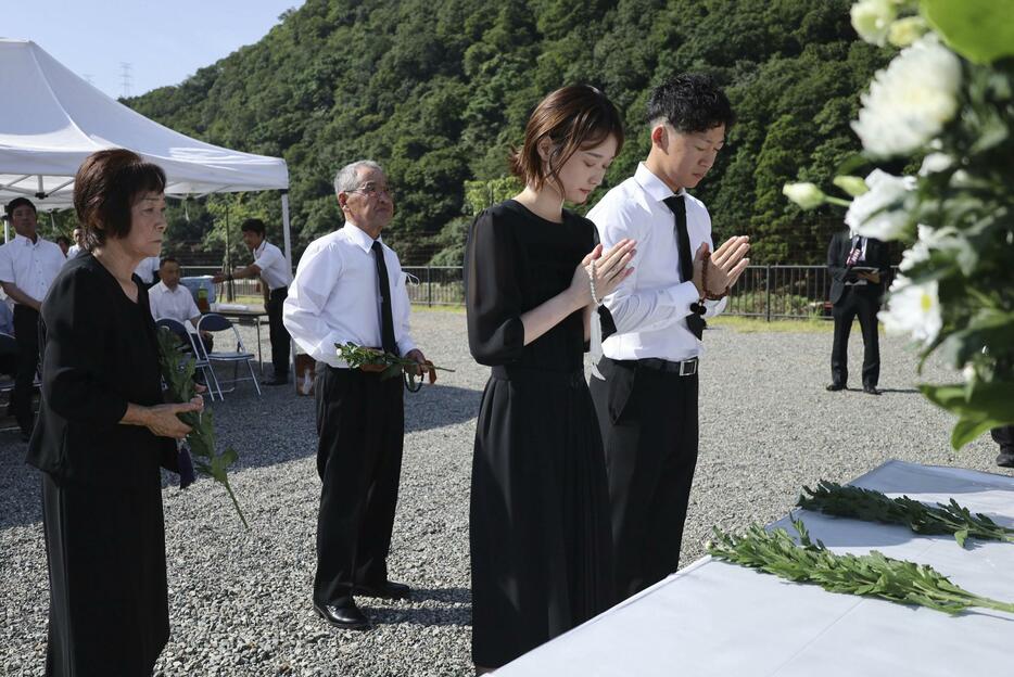 兵庫県佐用町で20人が亡くなった豪雨災害から15年となり、犠牲者の名前が刻まれたモニュメントの前で手を合わせる遺族ら＝9日午前