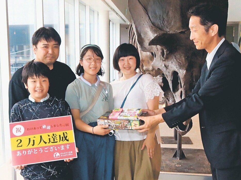 ２万人目の来場者となった北野さん（手前左）と家族ら＝氷見市芸術文化館